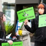 man in black jacket holding green paper